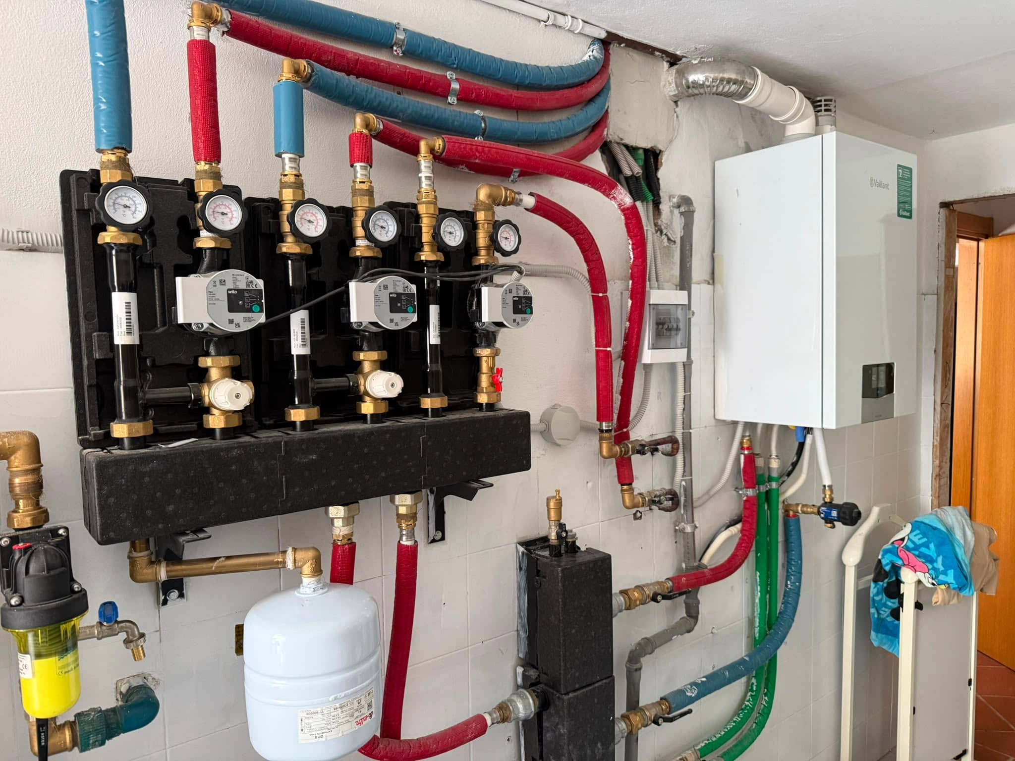 Caldaia Vaillant installata a parete con collettori e collegamenti idraulici a vista