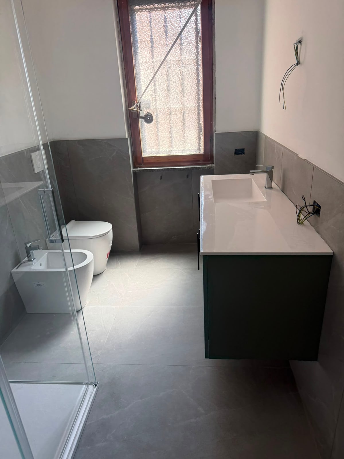 Bagno completato con doccia, sanitari e mobile lavabo scuro