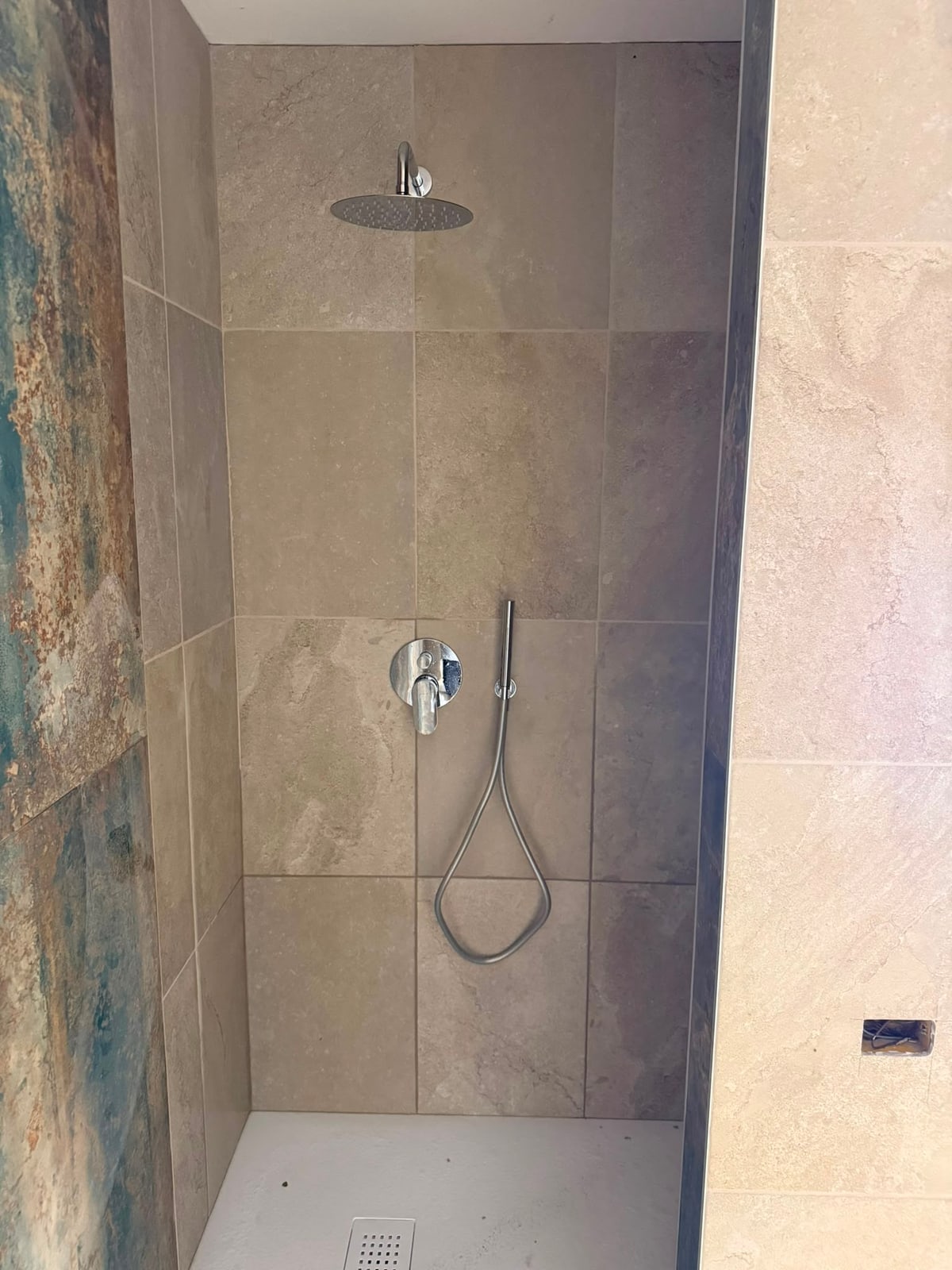 Zona doccia completata con rivestimento grigio